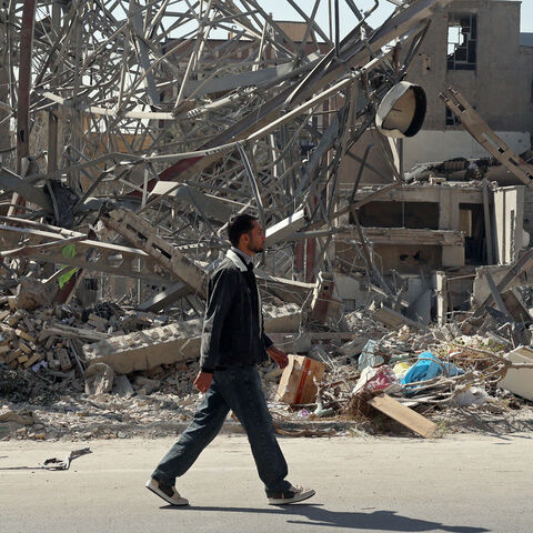 A man walks past destroyed buildings following airstrikes in central Tehran on March 4, 2026. 