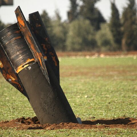 A boy walks past an unexploded missile that landed in an open field on the outskirts of Qamishli, eastern Syria, on March 5, 2026. 