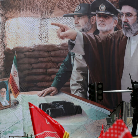 An Iranian security force officer stands guard next to a huge billboard of Iran's newly nominated supreme leader Ayatollah Mojataba Khamenei (pointing) during Al-Quds (Jerusalem) Day rally, a commemoration in support of the Palestinian people on the last Friday of the Islamic holy month of Ramadan, in Tehran on March 13, 2026. On February 28, Israel and the United States launched strikes on Iran, killing its supreme leader Ayatollah Ali Khamenei (photo bottom L) and triggering a war that spread across the M