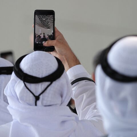 Attendees take a picture of French Prime Minister Edouard Philippe as he delivers a speech during a visit to the Louvre Abu Dhabi Museum on February 10, 2018, on Saadiyat island in the Emirati capital, to launch the French-Emirati "Year of Cultural Dialogue". (Photo by KARIM SAHIB / AFP) (Photo by KARIM SAHIB/AFP via Getty Images)