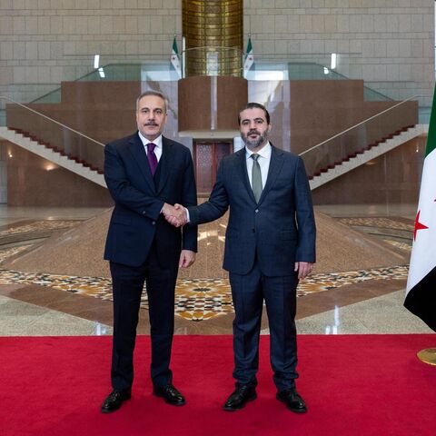 This handout photograph provided by the Turkish Foreign Ministry press service shows Turkish Foreign Minister Hakan Fidan (L) meeting with Syria's Foreign Minister Asaad al-Shaibani (R) in Damascus on Dec. 22, 2025. 