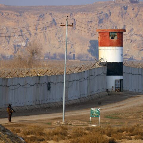 A member of the Popular Mobilization Forces patrols along a concrete wall at the Iraqi-Syrian border in Al-Qaim, west of Iraq, on Jan. 23, 2026. 