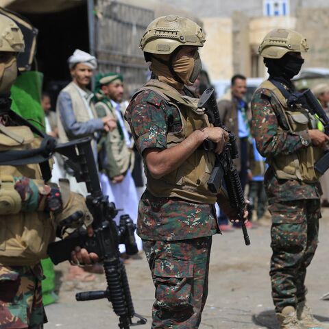 Members of Houthi security forces stand guard while supporters of Yemen's Houthi movement attend an event commemorating the ninth anniversary of the Saudi-led intervention in their country, in the capital, Sanaa, on March 26, 2026. 