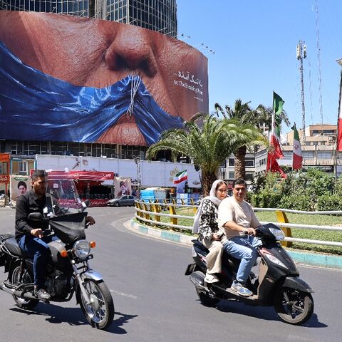 Commuters in Tehran drive past a billboard mocking US President Donald Trump over the Strait of Hormuz