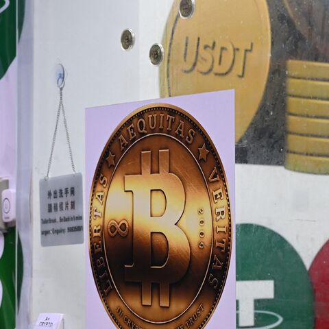 The symbols of bitcoin and the stablecoin Tether (USDT) are displayed at a cryptocurrency store in Hong Kong on July 29, 2025. 