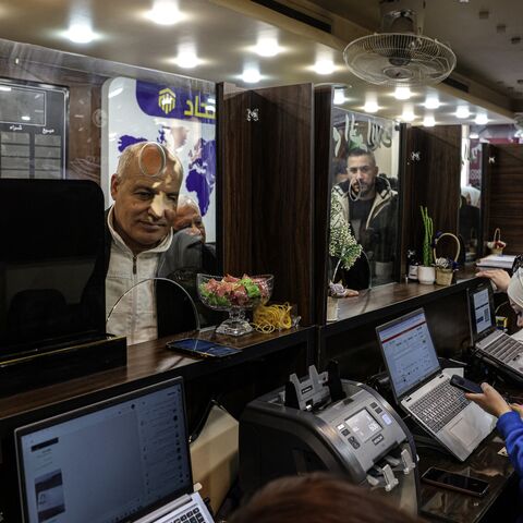 A Syrian citizen exchanges old banknotes for new notes released and distributed by the central bank, at a bank in the capital, Damascus, on Jan. 3, 2026.