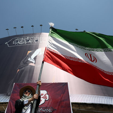 A woman holds an Iranian flag on a street in Tehran, Iran, June 30, 2026. Majid Asgaripour/WANA (West Asia News Agency) via REUTERS