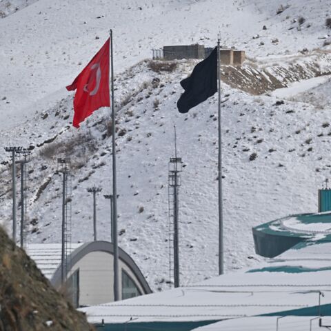 This photograph shows a Turkish national flag at the Razi-Kapikoy border crossing with Iran next to a black flag on the Iranian side, following the death of Iranian Supreme Leader Ayatollah Ali Khamenei, in eastern Turkey on March 2, 2026. 