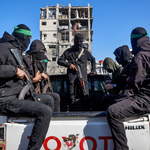 Palestinian Hamas militants arrive to secure the area as Egyptian workers accompanied by members of the International Committee of the Red Cross (ICRC), search for the last two remaining bodies of hostages -an Israeli soldier and a Thai national- from under the rubble of the Jabalia refugee camp, in the northern of Gaza Strip on Dec. 1, 2025.
