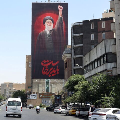 Motorists drive past a billboard bearing a picture of Iran's slain supreme leader Ali Khamenei, ahead of his funeral in Tehran on July 3, 2026. Iranian leaders began paying their respects on July 3 before the coffin of the country's late supreme leader Ali Khamenei, killed in the US-Israeli strikes that triggered the Middle East war, as Tehran prepared for a vast funeral. Khamenei's body arrived at Tehran's Grand Mosalla on July 3 ahead of ceremonies which are expected to draw millions. (Photo by AFP via Ge
