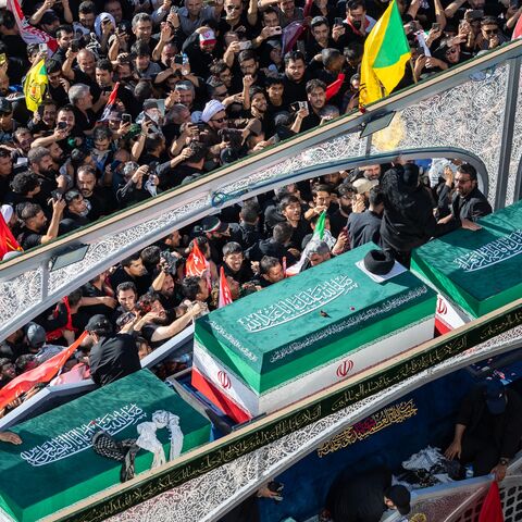 Mourners surge towards the turban-clad casket of Iran's slain Supreme Leader Ayatollah Ali Khamenei on July 9, 2026, in Mashhad, Iran. 