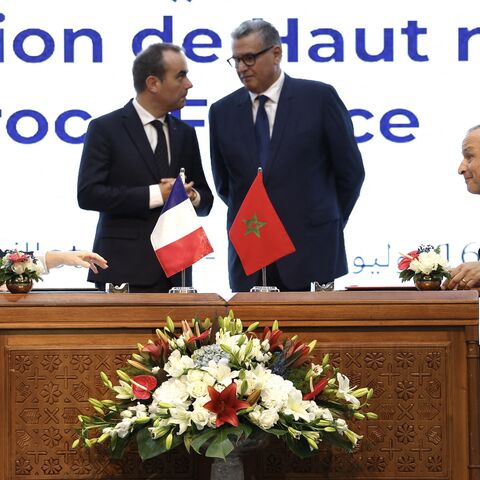 Director of European Affairs and Customs at La Poste Groupe Christelle Defaye-Geneste (L) and Morocco's Minister of Industry and Trade Ryad Mezzour (R) sign agreements between La Poste Groupe and Barid Al-Maghrib, alongside France's Prime Minister Sebastien Lecornu (C-L) and his Moroccan counterpart, Aziz Akhannouch, during a meeting in Rabat on July 16, 2026. 