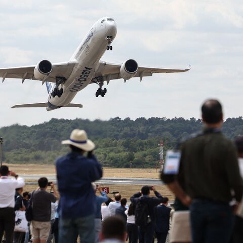 Spectators look on as an A350-1000 by the European plane maker Airbus takes off on the second day of the Farnborough International Airshow 2026, Farnborough, July 21, 2026.