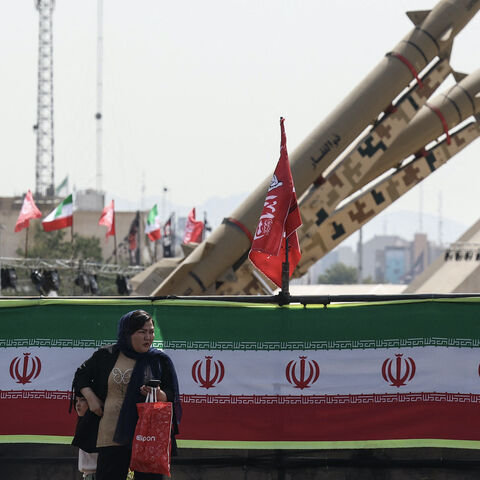 A woman stands next to Iranian-made Zolfaghar missiles displayed at Azadi Square in Tehran on July 24, 2026. 