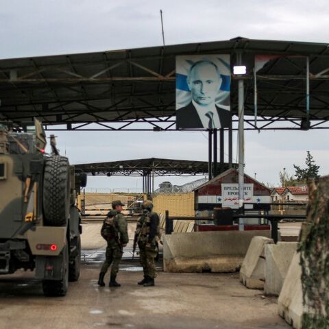 A portrait of Russia's President Vladimir Putin hangs above the military base of Hmeimim in Latakia province in western Syria in 2024