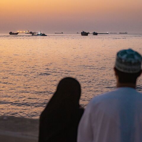 A couple watch oil tankers