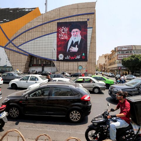 Motorists drive vehicles past a billboard depicting Iran's late supreme leader Ali Khamenei along a street in central Tehran on August 8, 2026. Hopes for an imminent US-Iran deal to end the blockage of the Strait of Hormuz added to optimism that oil and gas, along with other key products, would again start flowing freely after more than five months of war. But oil prices turned higher ahead of the weekend in the absence of any confirmation of an accord, amid reports that Iran was planning to block US and Is
