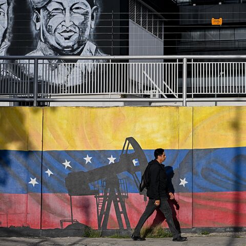A man walks past a mural depicting oil pumps and the Venezuelan flag, with portraits of Venezuelan independence leader Simon Bolivar (L) and former late President Hugo Chavez (R), in Caracas, Venezuela, on Sept. 3, 2026.