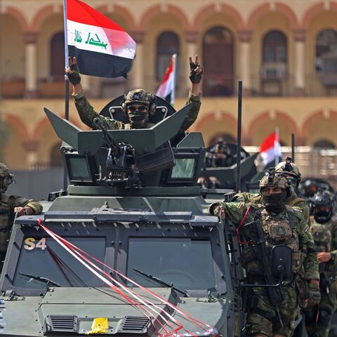 A member of the Iraqi security forces flashes the victory sign during a military parade