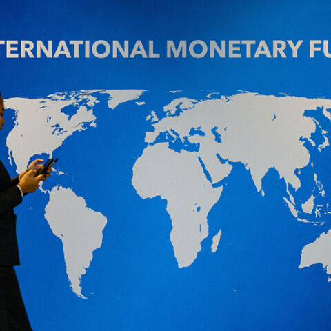 An attendee walks past signage displayed inside the venue for the Annual Meetings of the International Monetary Fund (IMF) and the World Bank Group (WBG) at the Queen Sirikit National Convention Center (QSNCC) in Bangkok on October 14, 2026. (Photo by ANTHONY WALLACE / AFP via Getty Images)