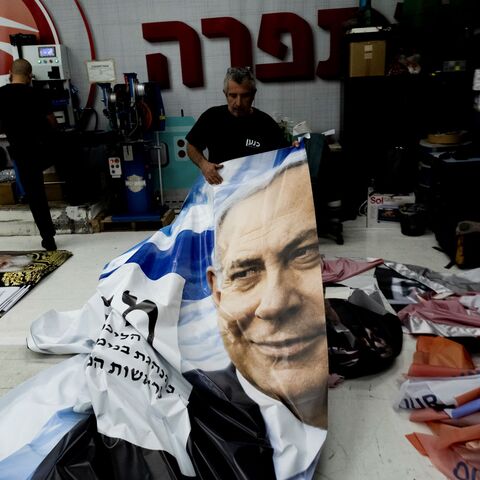 A print house worker produces a campaign poster showing Israeli Prime Minister Benjamin Netanyahu