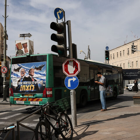 A bus bearing a campaign poster featuring Israeli Prime Minister and Likud party chairman Benjamin Netanyahu alongside US President Donald Trump drives through Jerusalem on October 26, 2026, on the eve of Israel's legislative elections. (Photo by AHMAD GHARABLI / AFP via Getty Images)