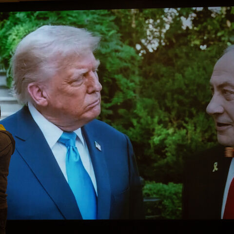 People stand in front of an electronic screen showing the face of U.S President Donald Trump and Israeli Prime Minister Benjamin Netanyahu at the Likud Party election-night event at the Teddy Hall on October 27, 2026 in Jerusalem.