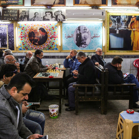 Iraqi men gather and socialise at Umm Kulthum Cafe on Rasheed street, the oldest street in the capital Baghdad on January 20, 2019. - Behind the dilapidated storefronts and collapsing colonnades of Rasheed Street lie the treasures of the Iraqi capital's cultural boom years but with young Iraqis listening to modern music and spending hours in hipster-style coffee shops, the boulevard that bustled non-stop in the 1970s is at risk of being passed over. (Photo by SABAH ARAR / AFP)        (Photo credit should re