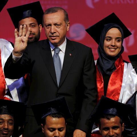 Turkey's President Tayyip Erdogan poses with students during a graduation ceremony in Ankara, Turkey, June 11, 2015. President Erdogan on Thursday urged the country's political parties to work quickly to form a new government, saying egos should be left aside and that history would judge anyone who left Turkey in limbo. In his first public appearance since Sunday's parliamentary election, Erdogan said no political development should be allowed to threaten Turkey's gains. He said he would do his part in find