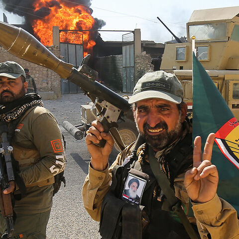 Fighters of Hashed Al-Shaabi (Popular Mobilization units) flash the victory gesture as they advance through a street in the town of Tal Afar, west of Mosul, after the Iraqi government announced the launch of the operation to retake it from Islamic State (IS) group control, on August 26, 2017. / AFP PHOTO / AHMAD AL-RUBAYE        (Photo credit should read AHMAD AL-RUBAYE/AFP/Getty Images)
