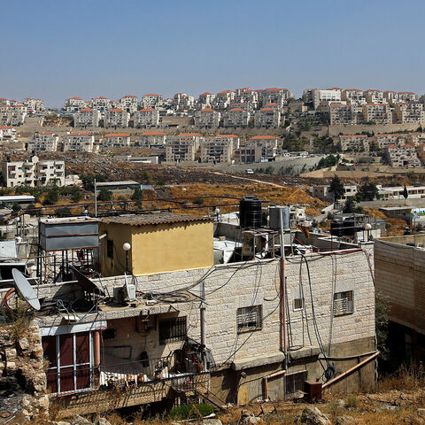 A view shows Palestinian houses in the village of Wadi Fukin as the Jewish settlement of Beitar Illit is seen in the background, in the Israeli-occupied West Bank June 23, 2019. Picture taken June 23, 2019.  REUTERS/Mussa Qawasma - RC1985B332A0