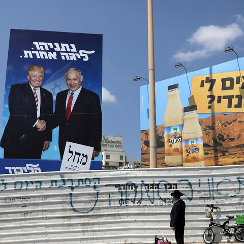 An ultra-Orthodox Jewish man stands next to a Likud party election campaign banner depicting Israeli Prime Minister Benjamin Netanyahu and U.S. President Donald Trump in Bnei Brak, Israel September 9, 2019. The words in Hebrew read, "Netanyahu, a different league" REUTERS/Ammar Awad - RC1F7BD95F00