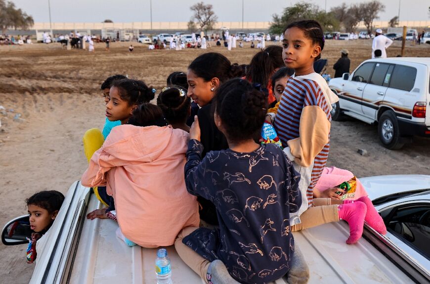 Children sit atop a car as they watch a traditional bullfight 
