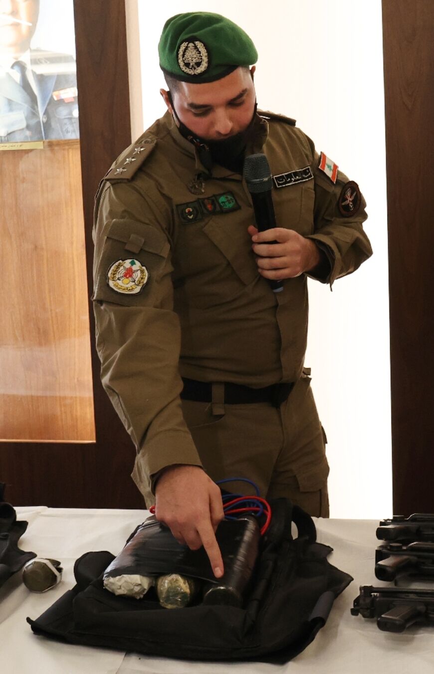 A member of Lebanon's Internal Security Forces shows an explosive vest they say was to have been used in the planned attack by the Islamic State group on Hezbollah's Beirut bastion