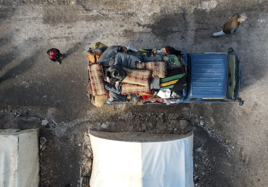 Internally displaced Syrians load their belongings onto a truck at a camp, as part of their move to a new purpose built housing complex near the Turkish-held Syrian city of Al-Bab