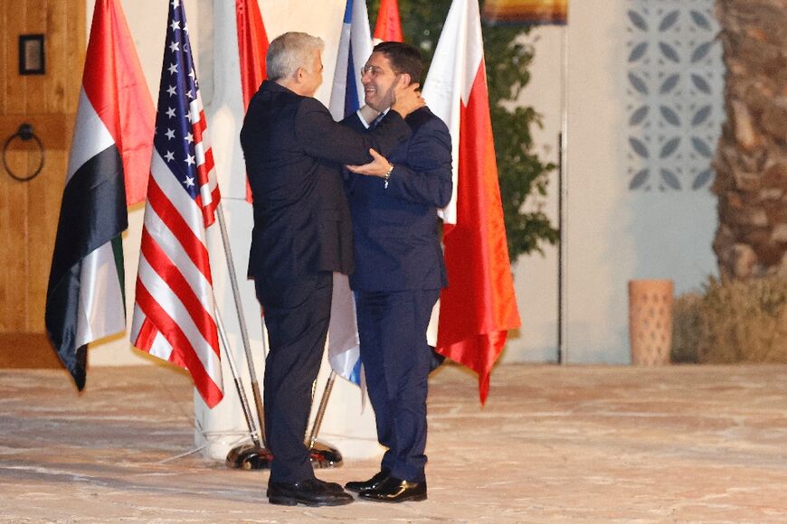 Israel’s Foreign Minister Yair Lapid (L) welcomes Morocco's Foreign Minister Nasser Bourita upon his arrival for a meeting in the southern Negev desert