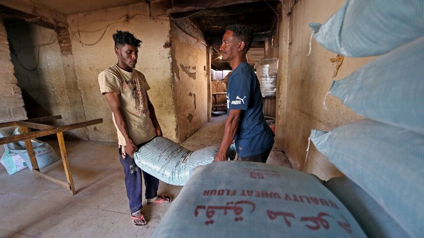 Workers pile bags of flour at a bakery in the capital Khartoum on October 11, 2021