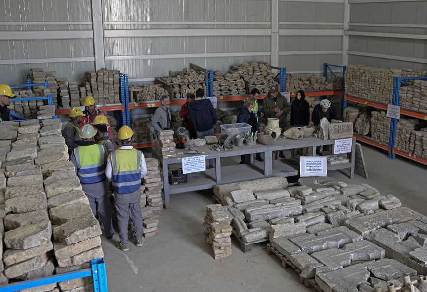 Foreign tourists and UN employees visit a warehouse of remains of archaeological artifacts inside the Great Mosque of Al-Nuri, in the northern Iraqi city of Mosul