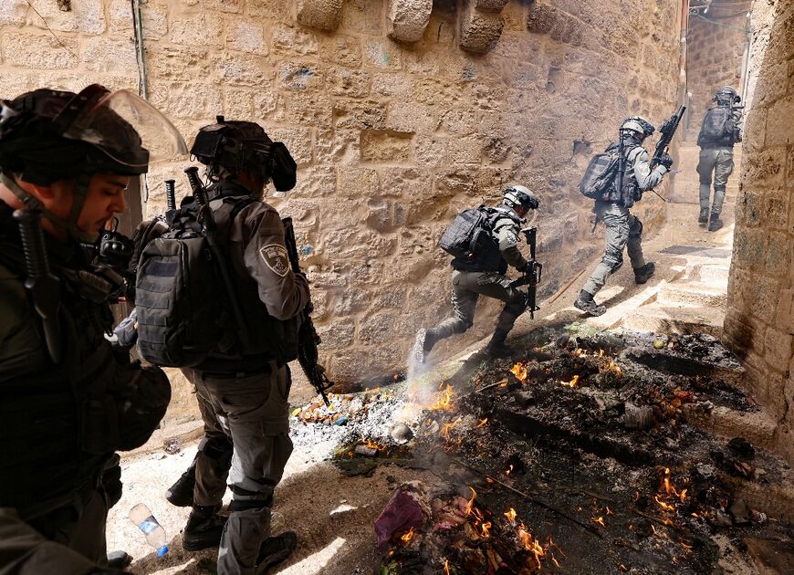 Israeli police pursue Palestinian protesters near Lion's Gate in Jerusalem's Old City on Sunday