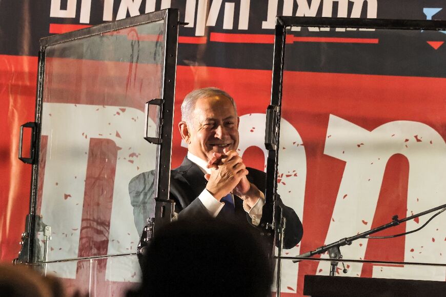 Former Israeli prime minister and current leader of the opposition Benjamin Netanyahu gestures to supporters behind a glass panel during an anti-government protest by Israeli right-wing demonstrators in Jerusalem