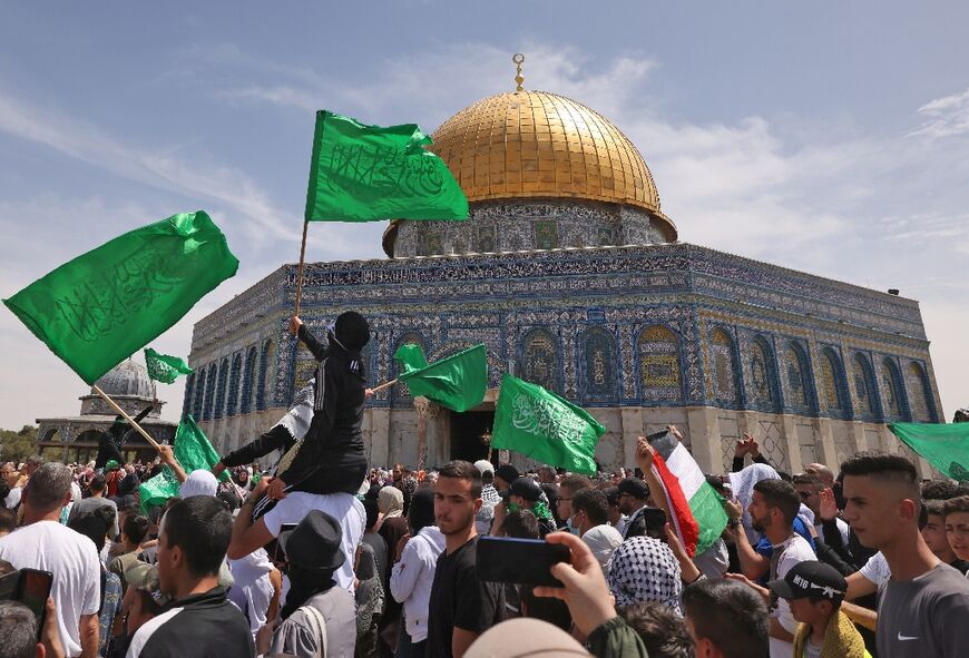 Palestinians wave national and Islamic flags inside Jerusalem's Al-Aqsa Mosque complex following prayers of the third Friday of the Muslim holy month of Ramadan