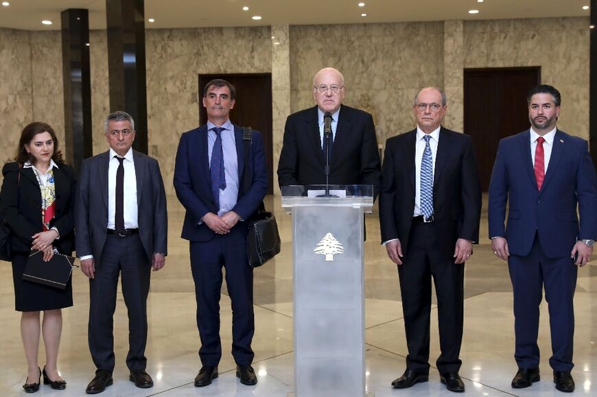 A handout picture provided by the Lebanese photo agency Dalati and Nohra on April 7, 2022 shows Lebanon's Prime Minister Najib Mikati (3rd R) holding a press conference alongside an International Monetary Fund (IMF) delegation 