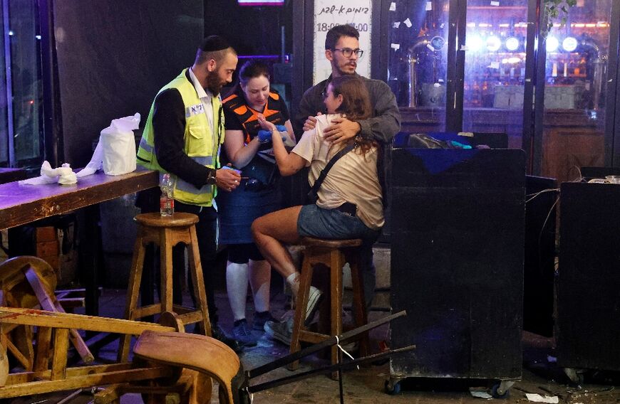 First responders tend to a woman in the aftermath of a shooting attack in Tel Aviv on April 7, 2022