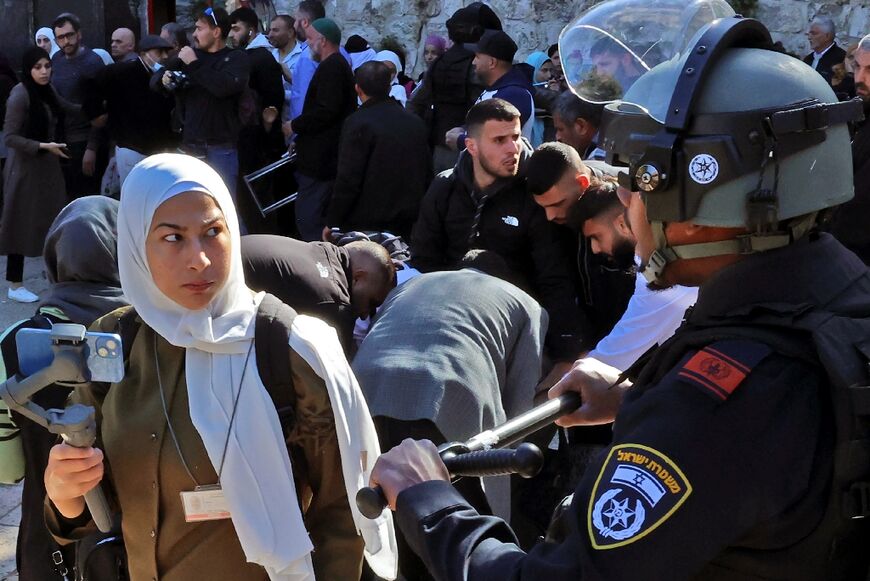 A woman watches as Israeli security forces intervene