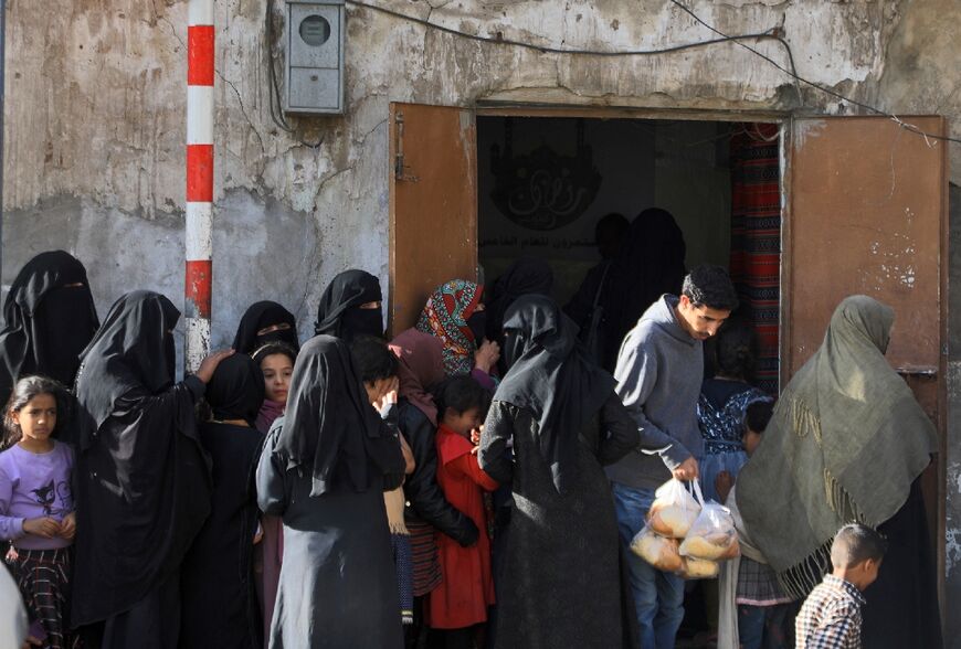 Yemenis wait in line to receive a free fast-breaking Iftar meal in the capital Sanaa during the Muslim holy month of Ramadan, on April 4, 2022