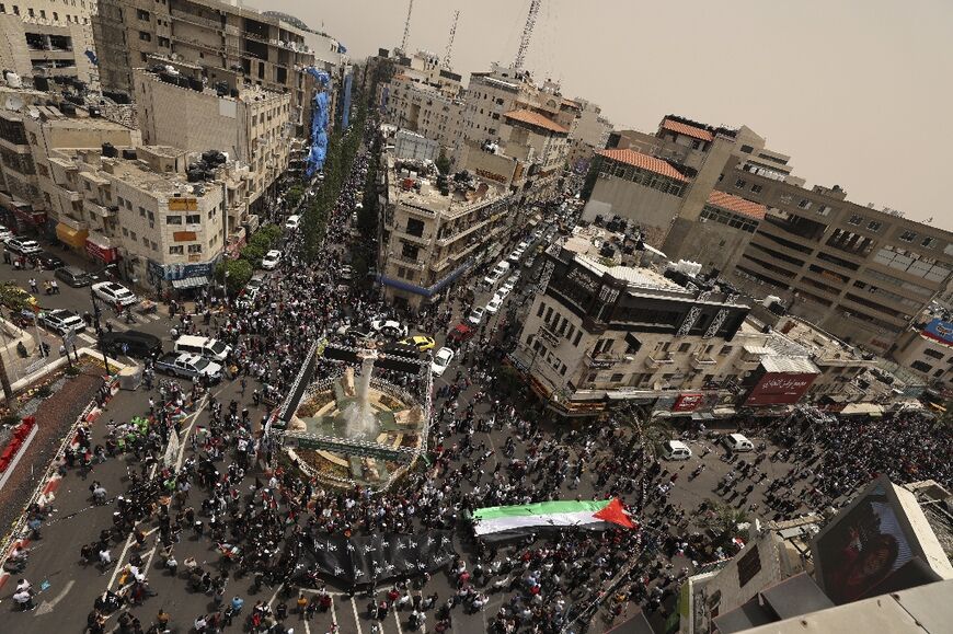 This aerial view shows Palestinians marching in a rally to mark the 74th anniversary of the "Nakba" or "catastrophe", in the occupied West Bank town of Ramallah, on May 15