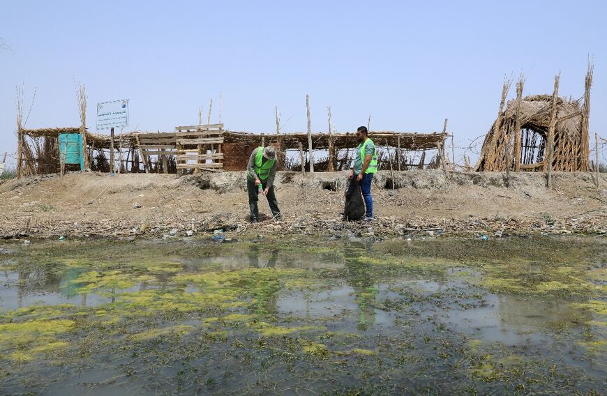 Iraqis work to collect the plastic trash that litters marshlands