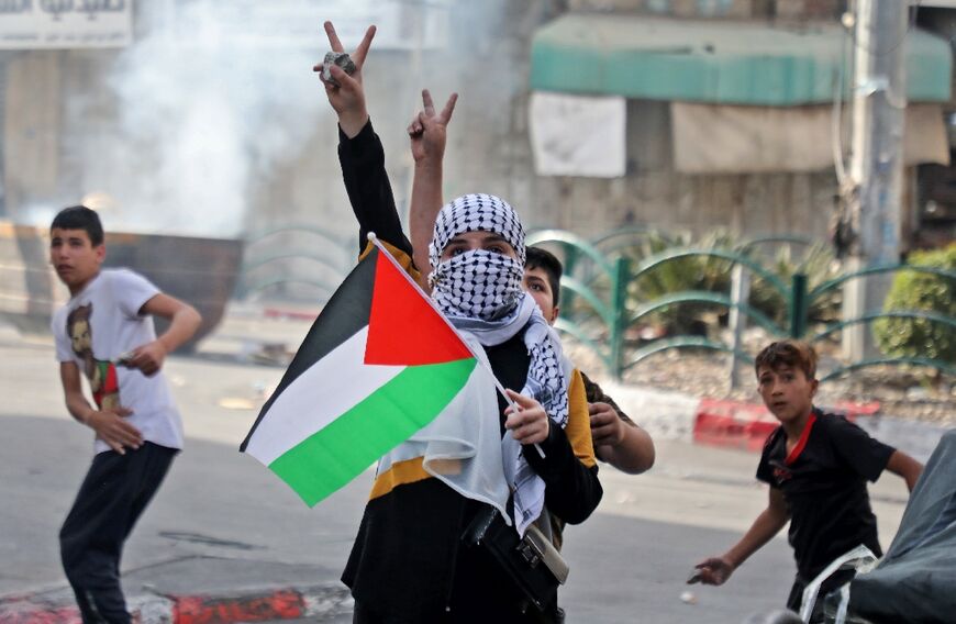 A Palestinian protester is seen during clashes with Israeli forces following a demonstration to denounce the annual nationalist "flag march" through Jerusalem, in the city of Hebron in the occupied West Bank on May 29, 2022