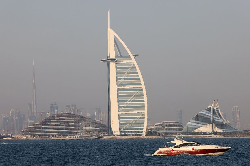 A yacht sails before the skyline of the Emirate of Dubai on April 21, 2022
