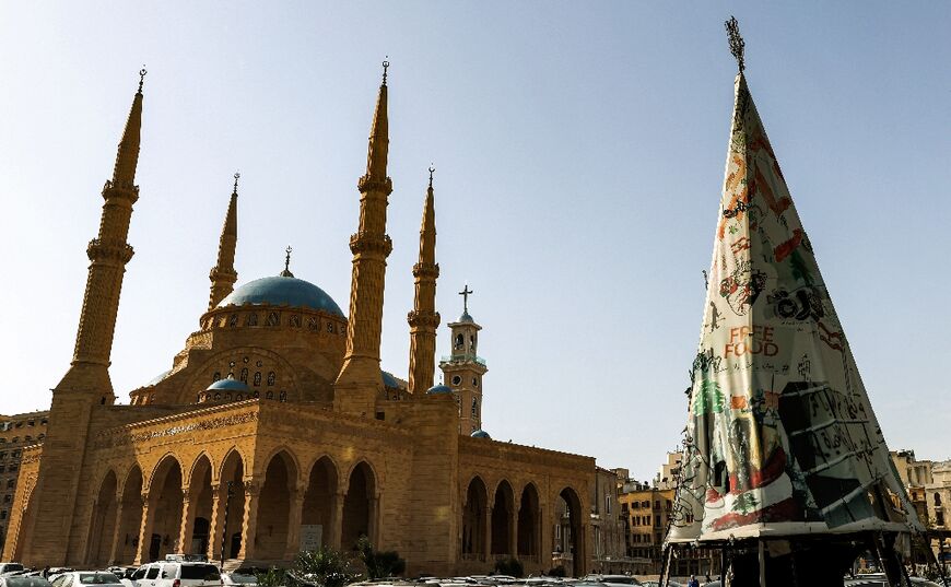 In Beirut, a Christmas tree stands near the Mosque of Mohammed al-Amin and the Maronite Cathedral of Saint George in the background, in a photo from December 14, 2021